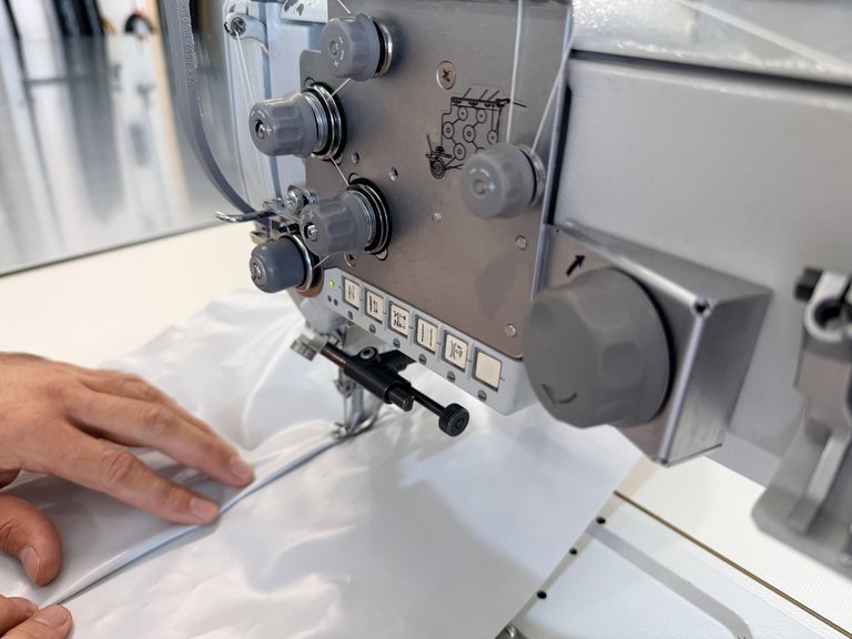 Mani che cuciono tessuto nautico nel laboratorio di selleria